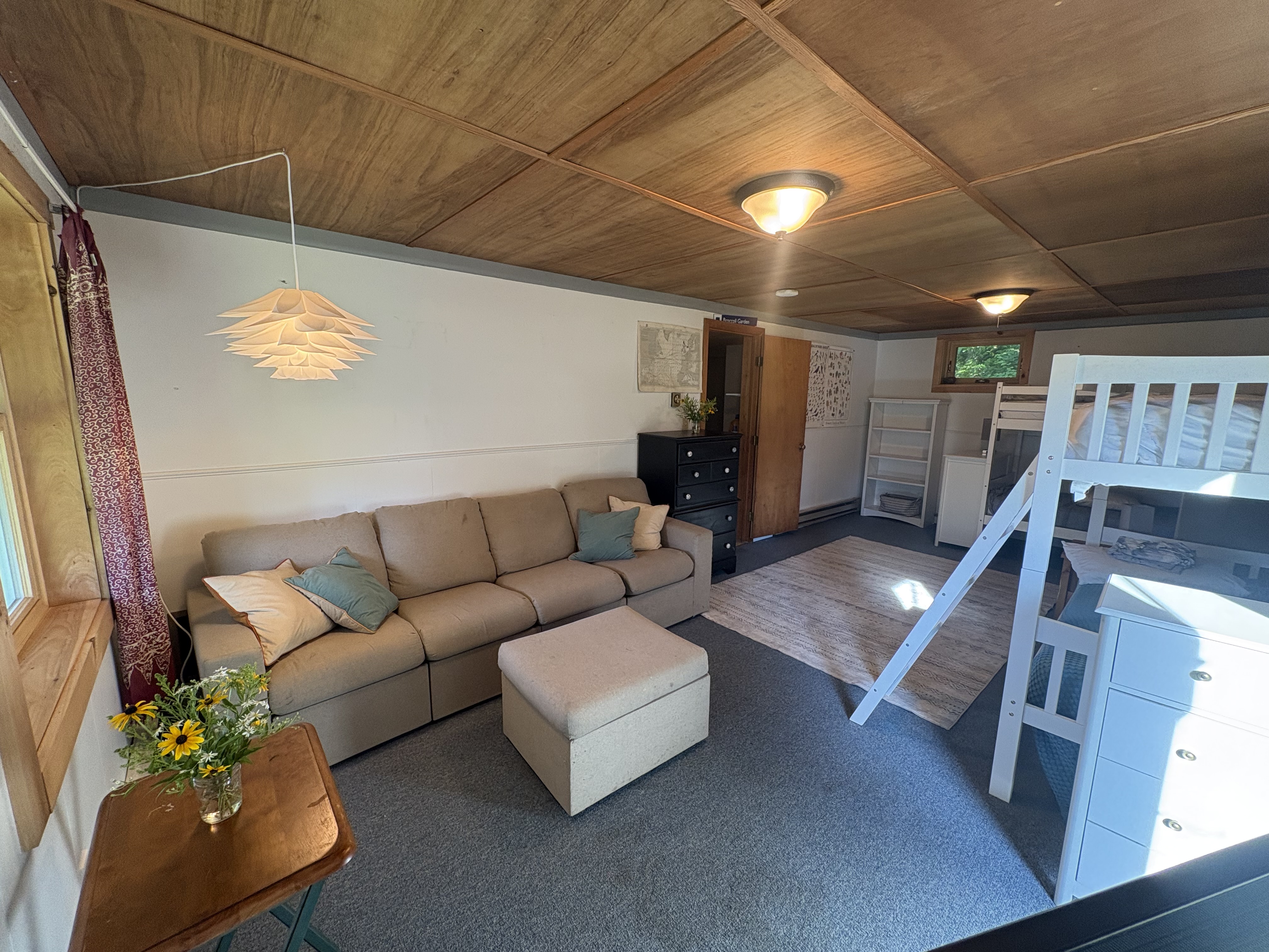 Bunk room sitting area with sofa and ottoman