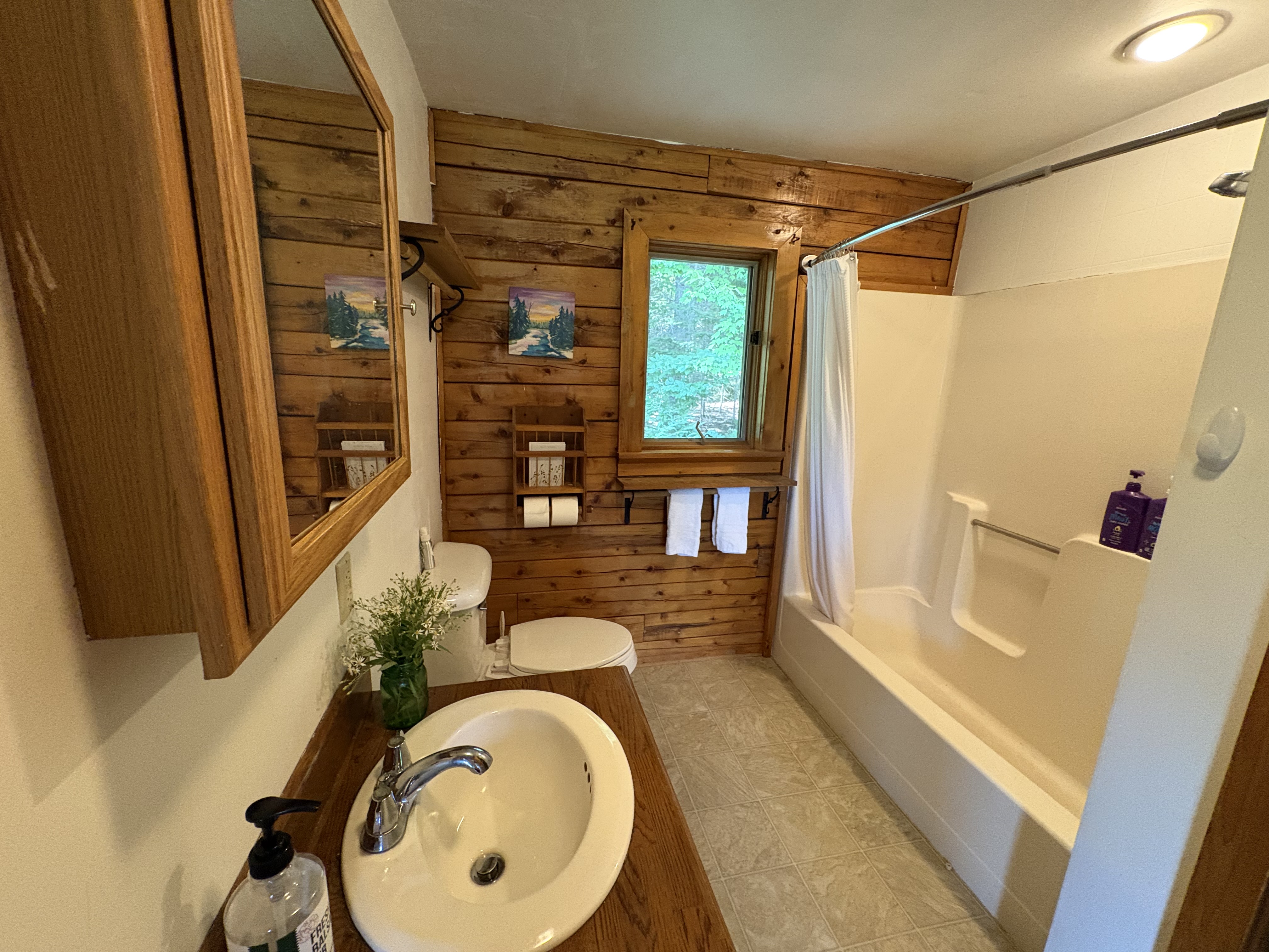 Second full bathroom with wood walls and tub