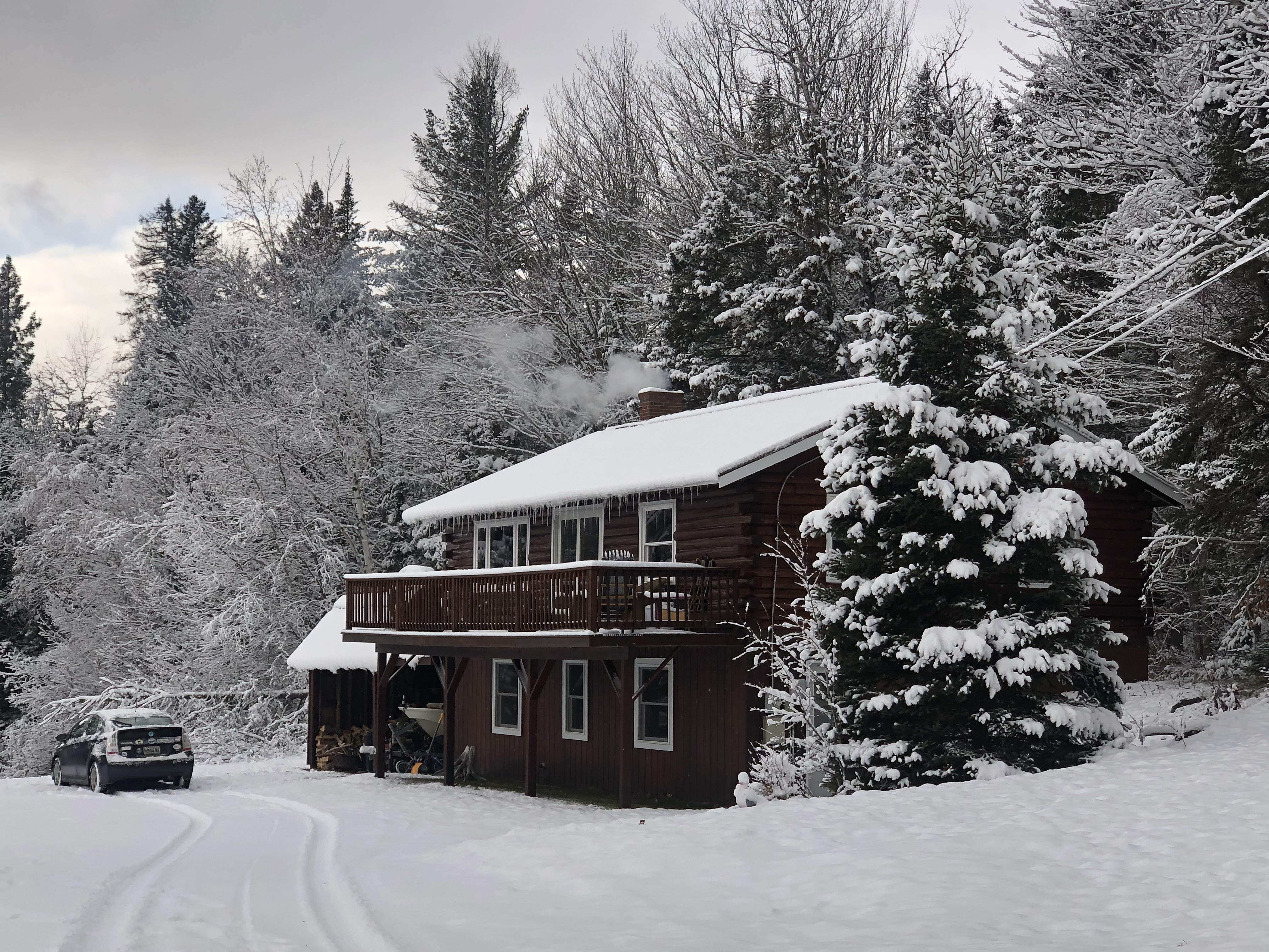 Log home in deep winter snow with smoke from chimney