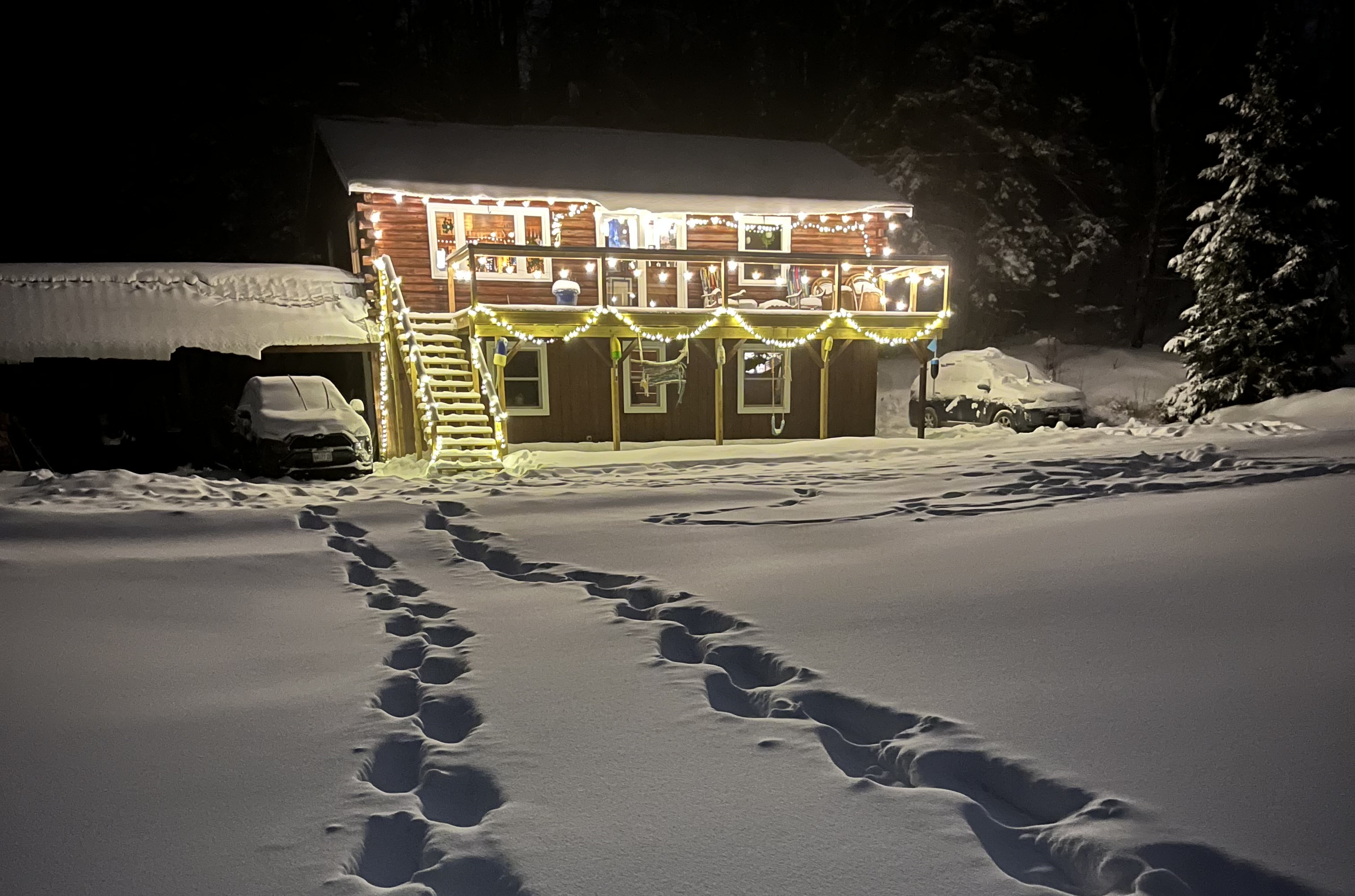 Log home lit up at night in deep snow