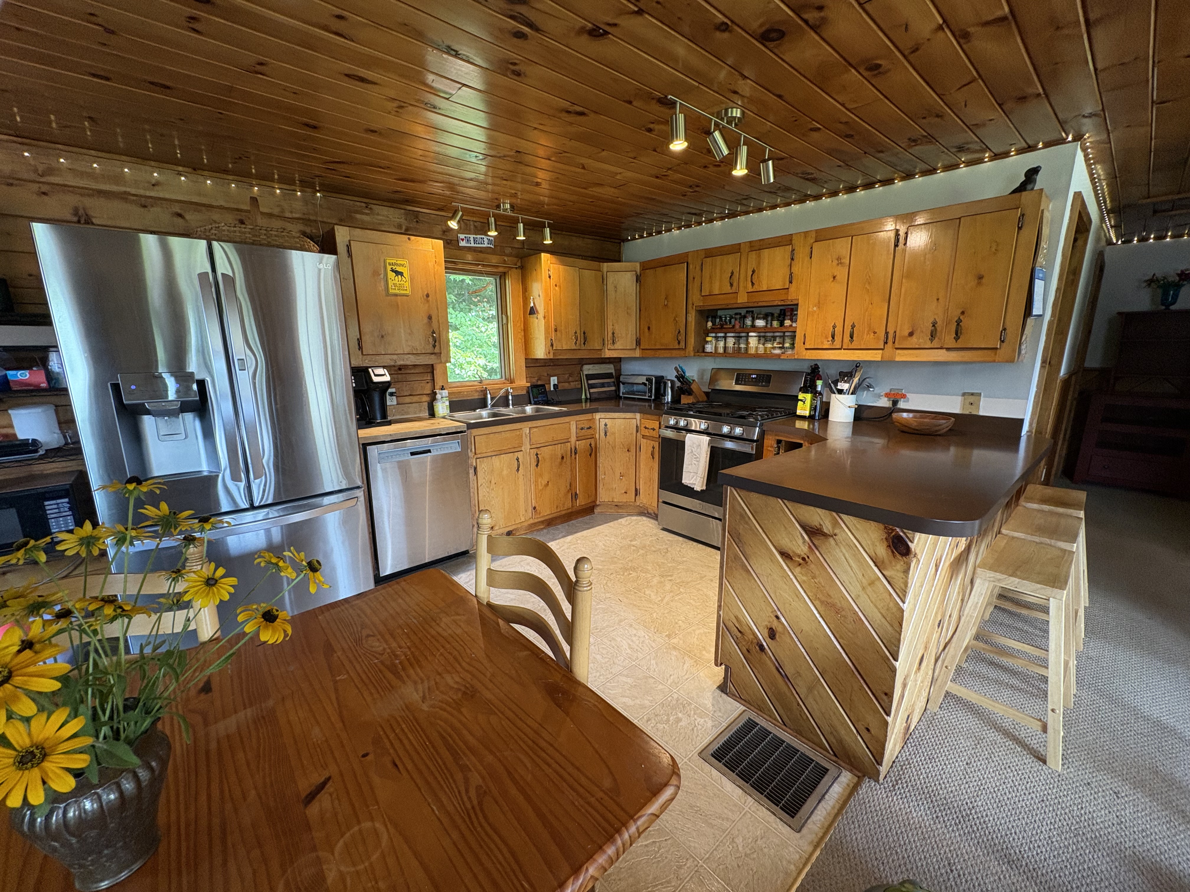 Fully stocked kitchen with stainless appliances and wood cabinets